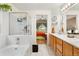 Bright bathroom with a soaking tub, a shower with glass doors, and a double sink vanity at 9756 Quay Loop, Broomfield, CO 80021