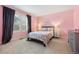 Charming bedroom features soft pink walls, a cozy bed, and natural light streaming through the window at 9756 Quay Loop, Broomfield, CO 80021