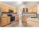 Modern kitchen boasts stainless steel appliances, granite countertops, wood cabinets, and a view of the front yard at 9756 Quay Loop, Broomfield, CO 80021