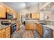 Charming kitchen features wood cabinets, stainless steel appliances, granite countertops, and hardwood floors at 9756 Quay Loop, Broomfield, CO 80021