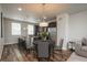 Dining area adjacent to a modern kitchen with an island and bar stools, illuminated by stylish pendant lighting at 630 E Hinsdale Ave, Littleton, CO 80122