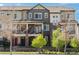 A modern townhouse showcasing a brick facade, multiple windows, and a bold red front door at 630 E Hinsdale Ave, Littleton, CO 80122