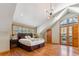 Bright bedroom boasts hardwood floors, ensuite patio, vaulted ceiling, and stylish lighting at 960 Whispering Pines Ln, Breckenridge, CO 80424