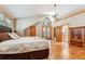 Bright bedroom boasts hardwood floors, ensuite patio, vaulted ceiling, and stylish lighting at 960 Whispering Pines Ln, Breckenridge, CO 80424