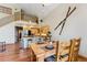 Open-concept dining area with hardwood floors, view of the upstairs loft, and kitchen nearby at 960 Whispering Pines Ln, Breckenridge, CO 80424