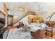 Bright living room with a grand staircase, fireplace, vaulted ceilings, and seamless flow into the kitchen and dining area at 960 Whispering Pines Ln, Breckenridge, CO 80424
