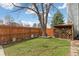 Backyard featuring a green lawn, wood fence, and firewood storage at 19411 E Milan Cir, Aurora, CO 80013
