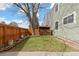 Backyard featuring a green lawn, wood fence, and firewood storage at 19411 E Milan Cir, Aurora, CO 80013