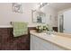 Bathroom with a single sink, vanity, and decorative tile accent wall at 19411 E Milan Cir, Aurora, CO 80013