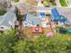 Aerial view of a cozy backyard with a well-maintained lawn, trees, and a vibrant red deck with blue outdoor furniture at 6282 Yank Ct, Arvada, CO 80004