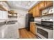 Bright kitchen with hardwood floors, countertops, wooden cabinets, stainless steel appliances, and modern lighting at 6282 Yank Ct, Arvada, CO 80004