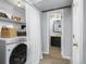 Laundry area with washer, dryer, shelves, and a view into a bathroom, providing convenience and functionality at 6282 Yank Ct, Arvada, CO 80004
