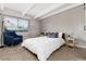Inviting bedroom with whitewashed wood accent wall, a cozy chair, and plenty of natural light at 555 E 10Th Ave # 206, Denver, CO 80203