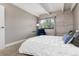 Bright bedroom featuring whitewashed wood accent wall and cozy sitting area at 555 E 10Th Ave # 206, Denver, CO 80203