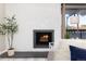 Living room featuring fireplace with tiled surround, wood mantle, and adjacent window with view at 555 E 10Th Ave # 206, Denver, CO 80203