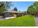Expansive backyard with lush green lawn, stone pathway, and a modern patio area for outdoor entertaining at 3275 19Th St, Boulder, CO 80304