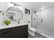 Modern bathroom featuring a walk-in shower, round mirror, and stylish black vanity with a white countertop at 3275 19Th St, Boulder, CO 80304