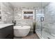 Bathroom featuring a soaking tub with stylish tile backsplash and a glass enclosed shower at 3275 19Th St, Boulder, CO 80304