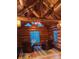 Inviting seating area features log walls, rustic rug, and stunning backyard views at 733 Rainbow Rd, Idaho Springs, CO 80452