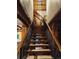 Wood staircase with wood banister showcases access to the home's upper level at 733 Rainbow Rd, Idaho Springs, CO 80452