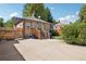 Charming backyard featuring a wooden staircase, lush grass, and mature trees at 1552 Hudson St, Denver, CO 80220