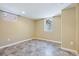 Finished basement area with tile flooring, neutral walls, and two windows offering natural light at 1552 Hudson St, Denver, CO 80220