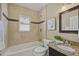 A well-lit bathroom with travertine tile, granite counters, and a shower-tub combination at 1552 Hudson St, Denver, CO 80220