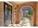 Charming front porch with brick arch, hanging lantern, and a glimpse of outdoor seating area at 1552 Hudson St, Denver, CO 80220