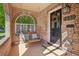 Inviting front porch with a porch swing, brick archway, and a decorative wreath on the front door at 1552 Hudson St, Denver, CO 80220