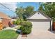 Spacious detached garage with a lush, green lawn and a brick house in the background at 1552 Hudson St, Denver, CO 80220