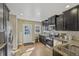 This is a modern kitchen with stainless steel appliances, granite counters, and dark wood cabinets at 1552 Hudson St, Denver, CO 80220