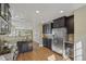 An open concept kitchen with stainless steel appliances, granite counters, and dark wood cabinets at 1552 Hudson St, Denver, CO 80220