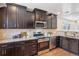 Well-appointed kitchen features dark cabinetry, stainless steel appliances, granite countertops, and a decorative tile backsplash at 1552 Hudson St, Denver, CO 80220