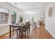 Bright living room featuring hardwood floors, a decorative fireplace, and a dining table with natural light from large windows at 1552 Hudson St, Denver, CO 80220
