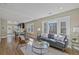 Bright living room with hardwood floors, large windows and comfortable seating arrangement flowing into the kitchen at 1552 Hudson St, Denver, CO 80220