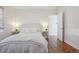Bright main bedroom featuring hardwood floors, neutral decor, and large windows for natural light and backyard views at 1552 Hudson St, Denver, CO 80220