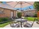 Outdoor patio with metal table and chairs set under a sun umbrella, nestled in a private backyard at 1552 Hudson St, Denver, CO 80220