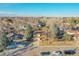 Aerial view of a suburban home with mature trees, a well-manicured lawn, and a two-car driveway at 8487 Yarrow Ct, Arvada, CO 80005