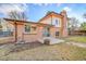 Brick home exterior with a cozy backyard featuring a small patio and well-maintained lawn at 8487 Yarrow Ct, Arvada, CO 80005