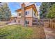 Back exterior of a two-story home with a brick chimney and a spacious fenced yard at 8487 Yarrow Ct, Arvada, CO 80005