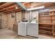 Unfinished basement with exposed beams, concrete walls, laundry area, and storage shelving at 8487 Yarrow Ct, Arvada, CO 80005