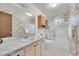 Bathroom with a single sink vanity, sliding shower doors, and decorative wallpaper at 8487 Yarrow Ct, Arvada, CO 80005