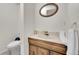 Bathroom with marble vanity top and oval mirror and light colored flooring at 8487 Yarrow Ct, Arvada, CO 80005