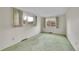 Bright bedroom featuring green carpet, white walls, and natural light from two windows at 8487 Yarrow Ct, Arvada, CO 80005