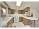 Functional kitchen featuring a breakfast bar, white countertops, and ample cabinet space at 8487 Yarrow Ct, Arvada, CO 80005