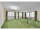 Spacious living room featuring vintage green carpet, natural light, and classic chandelier at 8487 Yarrow Ct, Arvada, CO 80005