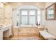 Bright bathroom showcasing a luxurious soaking tub with elegant pillars and natural light at 13 Buell Mansion Pkwy, Englewood, CO 80113