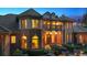 Stunning two-story brick home featuring a private balcony, arched windows, and manicured landscaping at 13 Buell Mansion Pkwy, Englewood, CO 80113