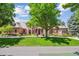 Charming red brick home with lush green lawn, mature trees, and inviting front entrance at 13 Buell Mansion Pkwy, Englewood, CO 80113