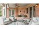 Covered patio with brick fireplace, comfortable seating, and ceiling fan at 13 Buell Mansion Pkwy, Englewood, CO 80113